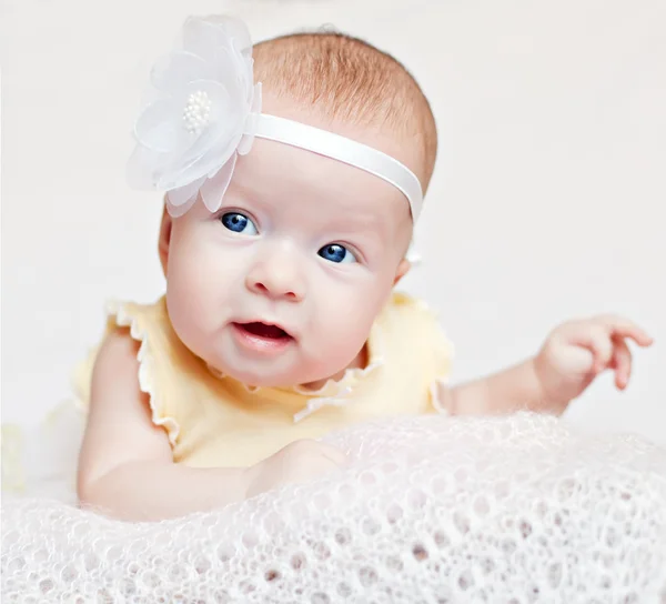 Mignon nouveau-né avec des fleurs souriantes — Photo