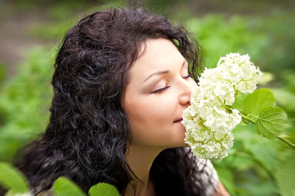 Linda garota cheirando flores — Fotografia de Stock