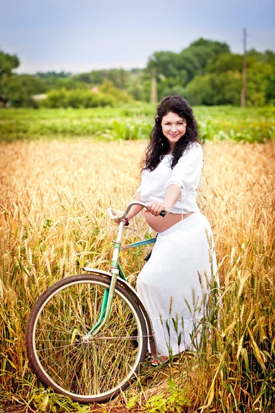 Słodkie dziewczyny w ciąży z rowerem w polu — Zdjęcie stockowe