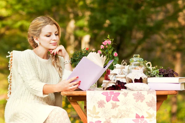 Мила дівчина п'є чай в саду — стокове фото