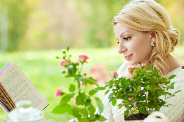 Мила дівчина в саду читає книгу — стокове фото