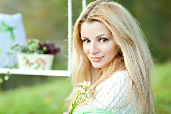 Mignonne blonde avec un bouquet de marguerites et de swing — Photo