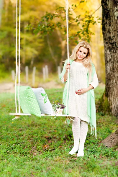 Cute pregnant girl and swing — Stock Photo, Image