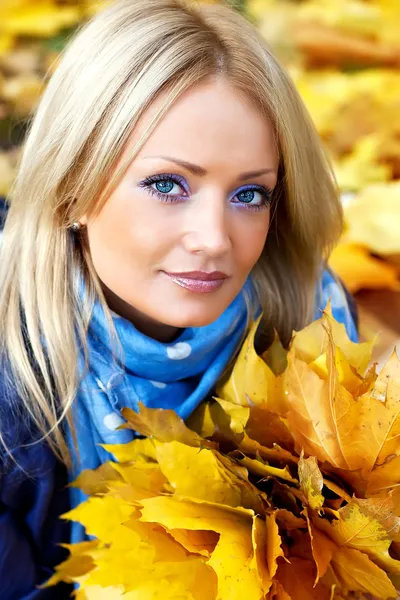 Söt blondin med en bukett av hösten lämnar — Stockfoto