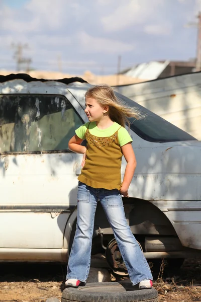 Menina posando ao lado de uma máquina quebrada — Fotografia de Stock
