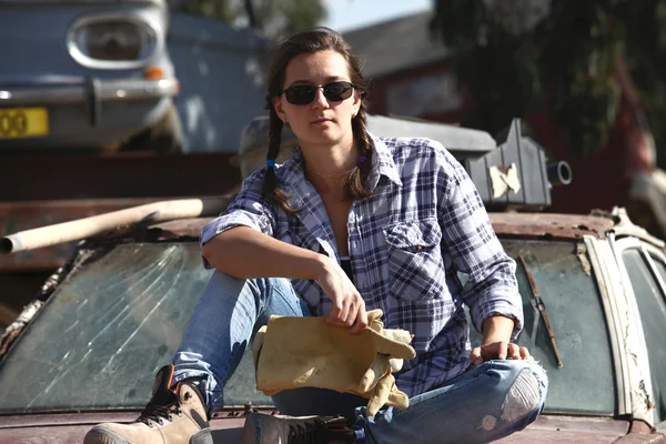 Kvinna poserar i en deponi auto — Stockfoto