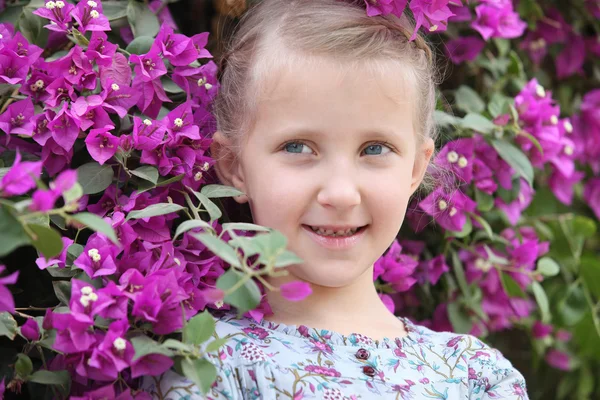 ライラック色の花の背景とポーズの女の子 — ストック写真