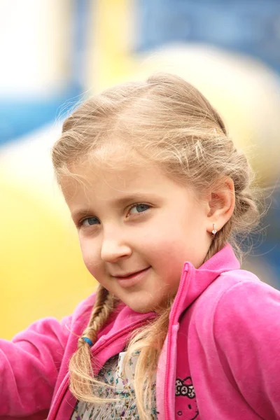 Portret van een jong meisje vormt een glimlach — Stockfoto