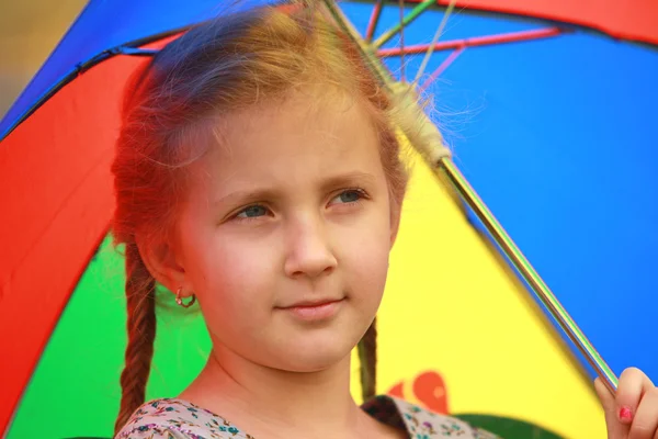 Porträt eines kleinen Mädchens mit einem Lächeln und einem Regenschirm — Stockfoto