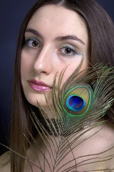 Woman with peacock feather — Stock Photo, Image