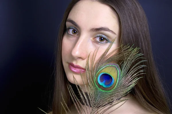 Woman with peacock feather — Stock Photo, Image
