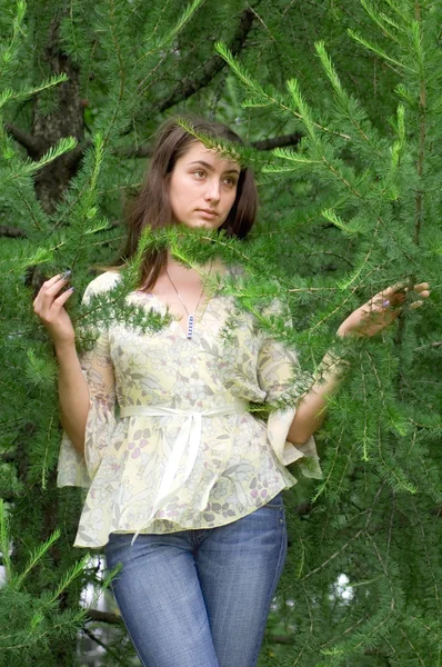 Girl in green branches — Stock Photo, Image