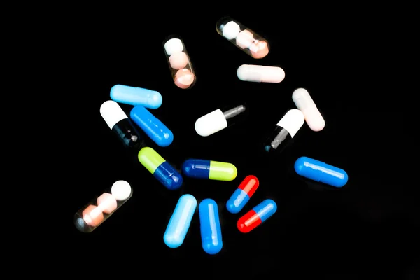 Färgade piller på svart bakgrund — Stockfoto