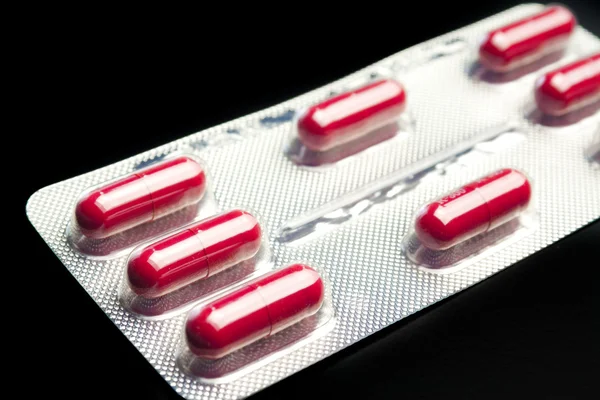 Blistra tabletek czerwony na białym tle — Zdjęcie stockowe