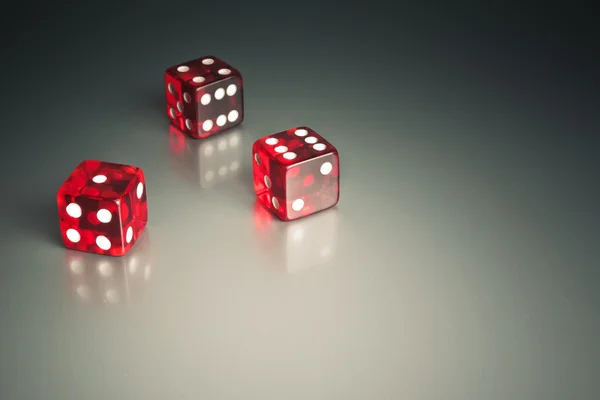 Three dice in the corner on a silver table — Stock Photo, Image
