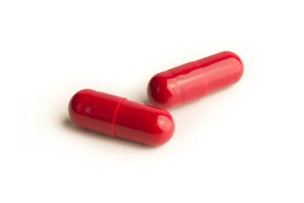 Pilules rouges sur fond blanc — Photo