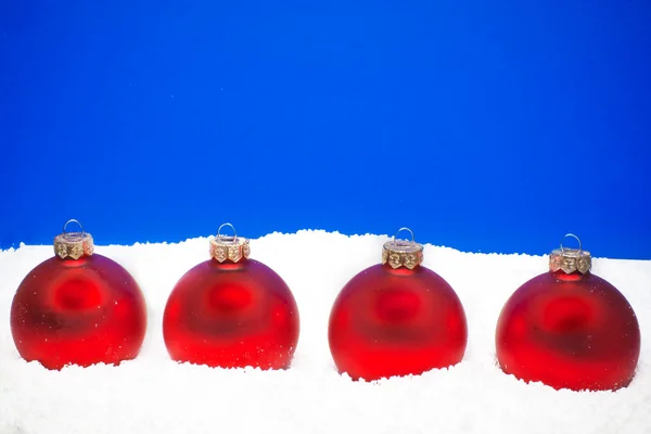 Four christmas balls on the snow — Stock Photo, Image