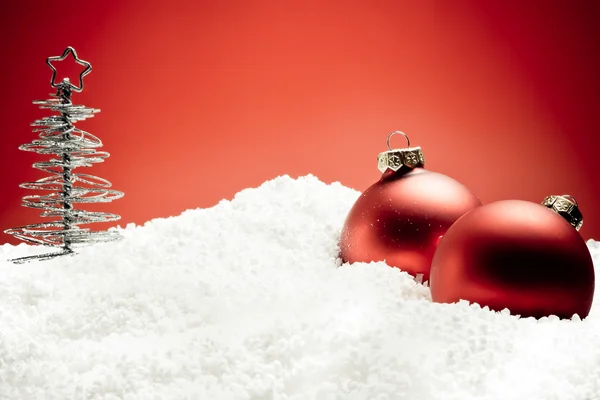 Різдвяна ялинка біля червоних кульок на снігу — стокове фото