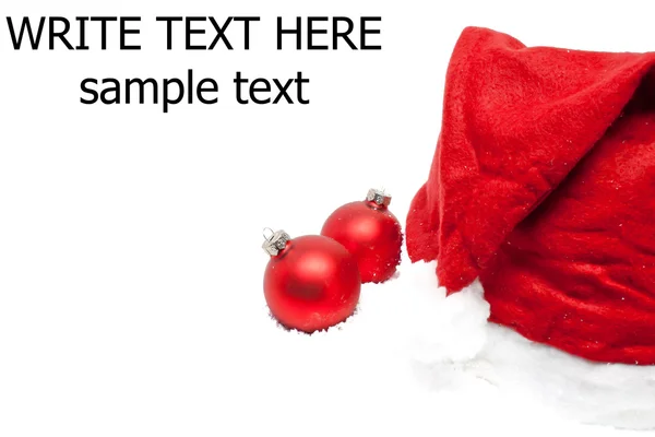 Bolas de Natal com chapéu vermelho de Papai Noel na neve — Fotografia de Stock