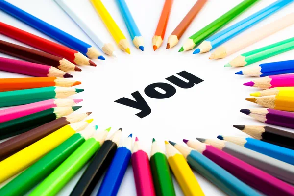 Molte matite colorate disposte in cerchio sulla parola — Foto Stock