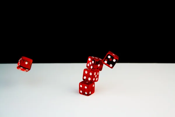 Detail van vijf rode dobbelstenen op zwarte en witte achtergrond in beweging — Stockfoto