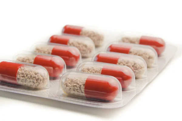 Fechar a embalagem blister de comprimidos vermelhos isolados — Fotografia de Stock