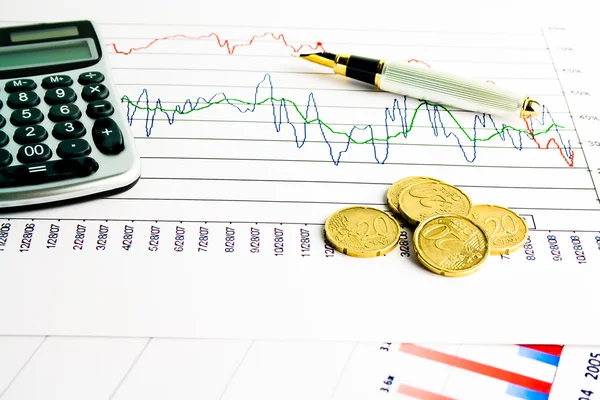 Calcolatrice e monete sul grafico finanziario — Foto Stock
