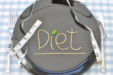 The word diet written with spaghetti on a plate with a measuring tape clipart