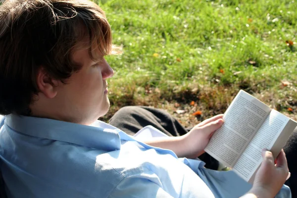 Tonåring uppslukad av boken utomhus — Stockfoto