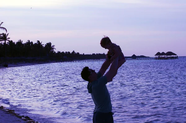 父亲和一名儿童在日落海滩上 — 图库照片