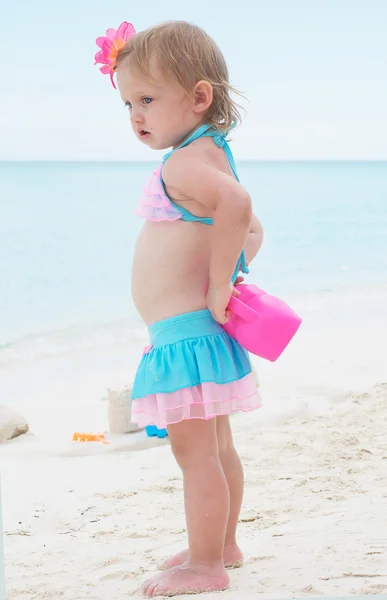 Bir bebek kız sahilde ona oyuncaklar ile oynuyor — Stok fotoğraf