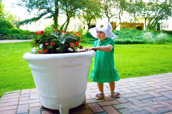 Una bambina e un vaso di fiori — Foto Stock