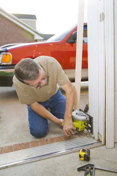 Carpenter sawing door casing — Stock Photo, Image