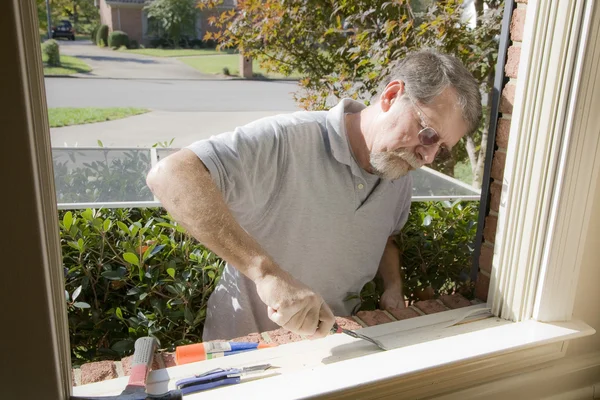 Carpinteiro reparação moldura da janela — Fotografia de Stock