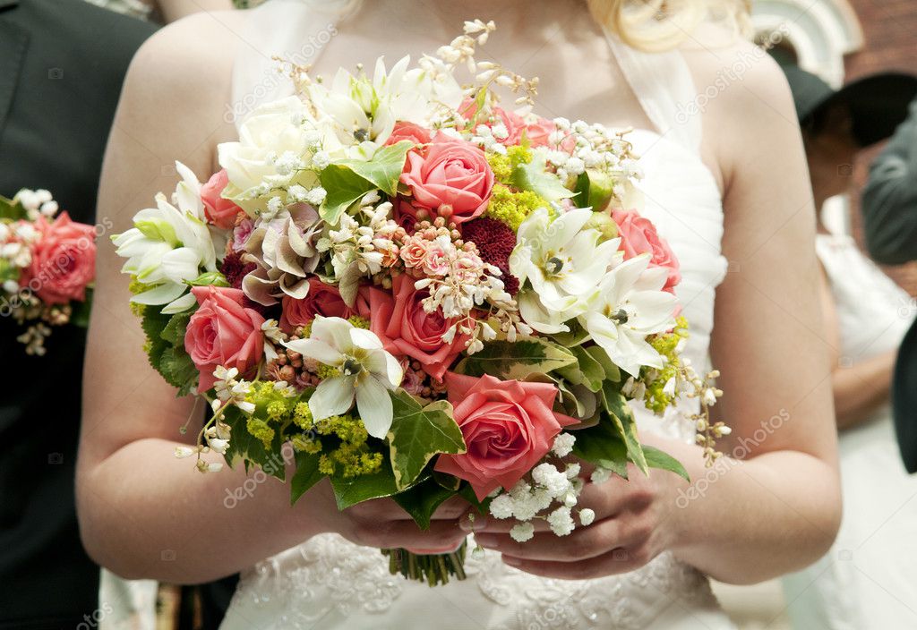 Bride holding bunch of flowers at wedding