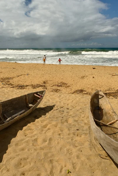 Pirogue et enfants sur une plage tropicale — Fotografie, imagine de stoc