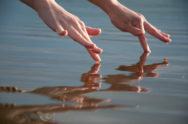 Руки с капельками над водой Стоковое Фото