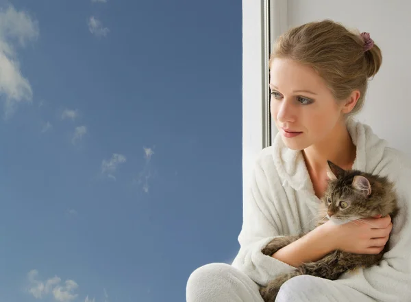 Dívka s kočkou, při pohledu z okna — Stock fotografie