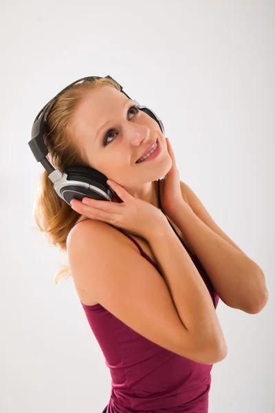 Menina atraente feliz em fones de ouvido escuta música — Fotografia de Stock
