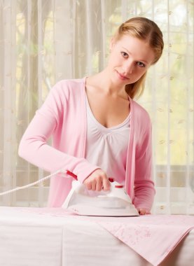 Happy woman ironing clothes clipart