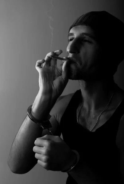 Zły człowiek w kajdankach z papierosem — Zdjęcie stockowe