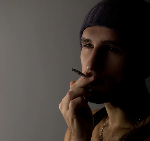 Portrett av en ung mann med en sigarett – stockfoto