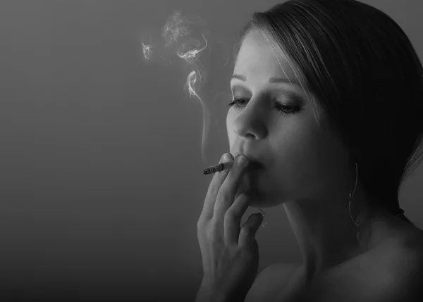 Schöne junge Frau raucht eine Zigarette — Stockfoto