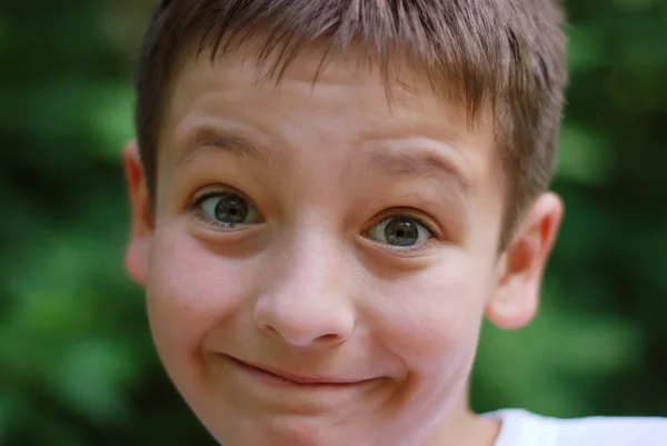 Leuke jongen gezicht met wenkbrauwen verhoogde, close-up — Stockfoto