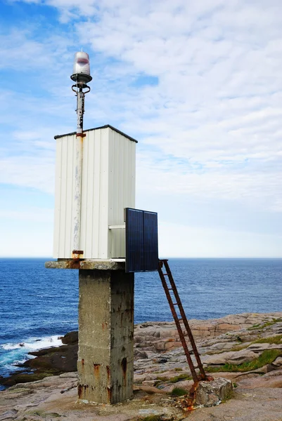 Małe latarnia morska z baterii słonecznej na skale. — Zdjęcie stockowe