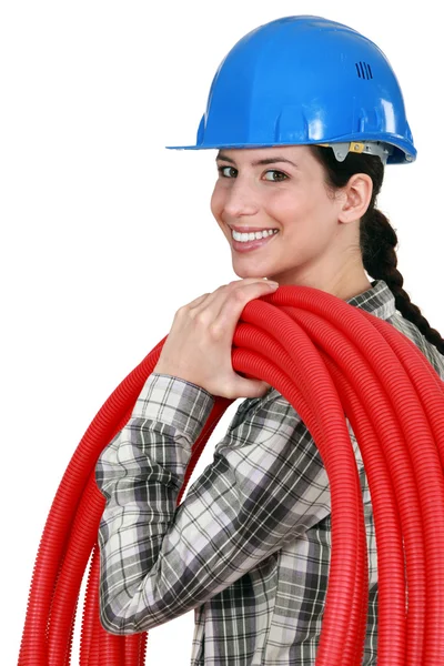 A woman carrying pipes. — Stock Photo, Image