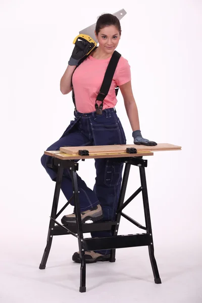 Girl with a saw at a workbench — Stock Photo, Image