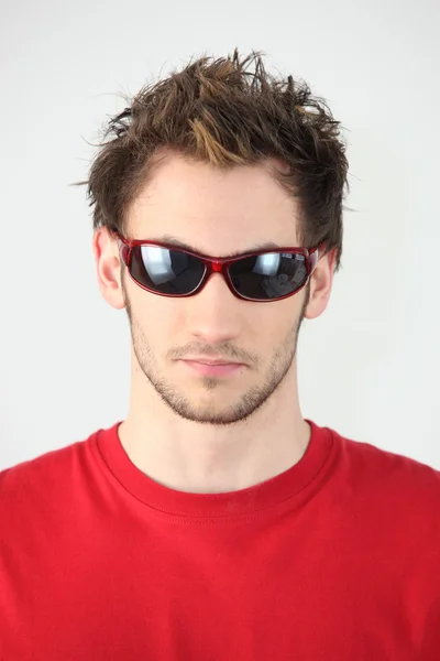 Junger Mann mit rot umrandeter Sonnenbrille — Stockfoto