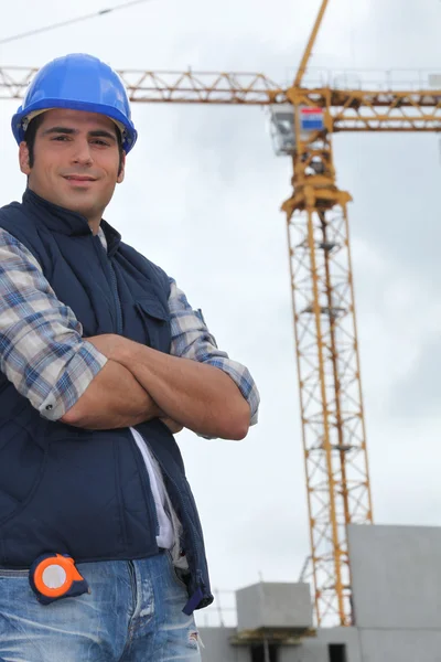Trabajador de la construcción frente a una grúa —  Fotos de Stock