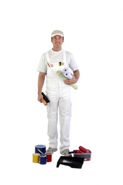 Full-length shot of house painter with tins of paint at his feet clipart